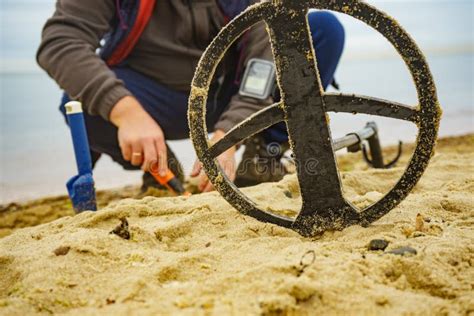 Volontario con metal detector sulla spiaggia