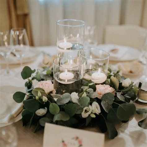 Centrotavola matrimonio verde scuro con candele e fogliame