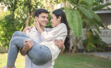 Un uomo che porta una donna in braccio oltre una soglia