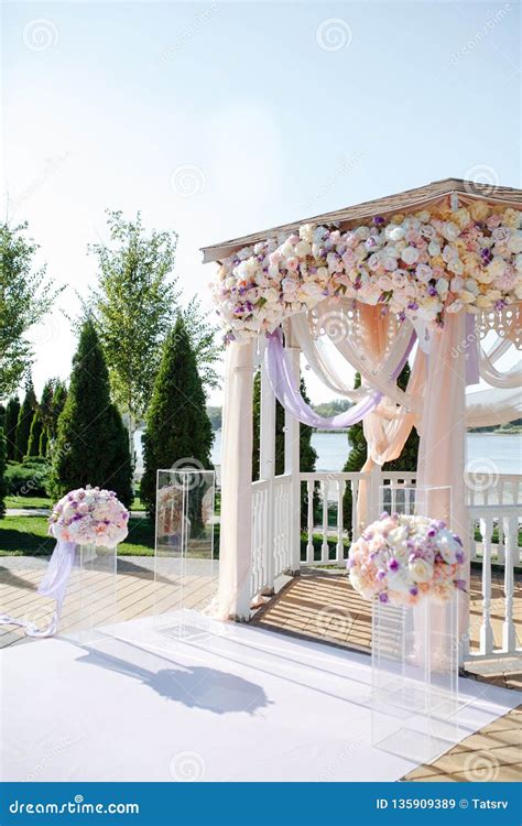 Arco nuziale in legno decorato con fiori e tessuti