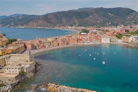 Veduta panoramica della Baia del Silenzio con le case colorate e il mare calmo.