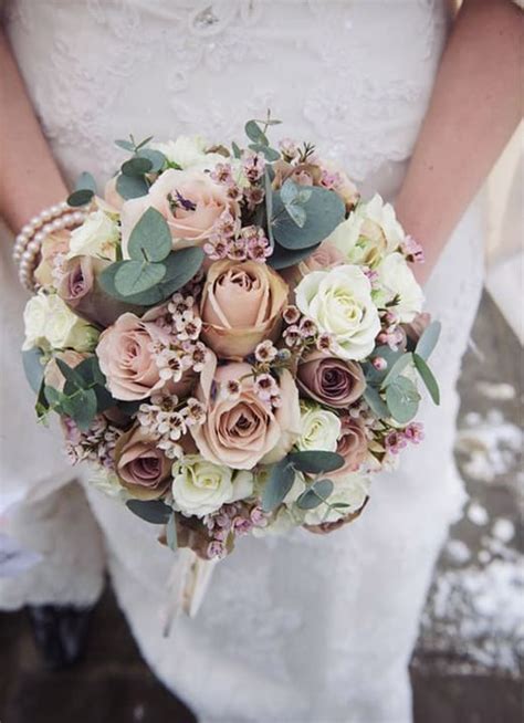 Dettaglio di un bouquet da sposa con fiori tropicali e foglie verdi