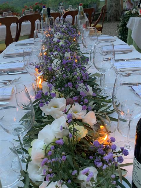 Dettaglio di un tavolo apparecchiato con fiori e candele in una villa toscana