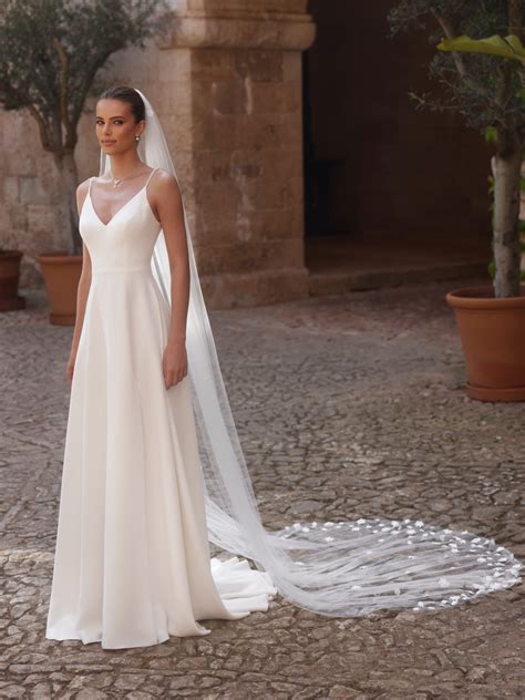 Sposa in abito bianco con un velo che copre parzialmente il suo volto, in un contesto di matrimonio.