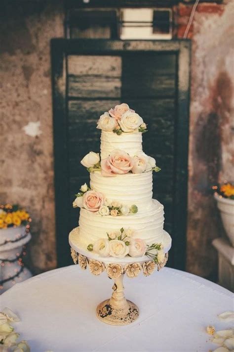 Torta nuziale con decorazioni floreali nei toni del cipria, verde e giallo
