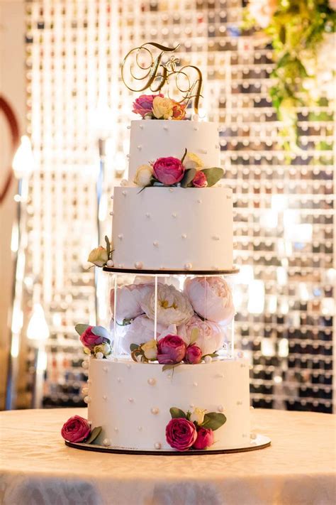 Torta nuziale in stile gravity cake con decorazioni floreali