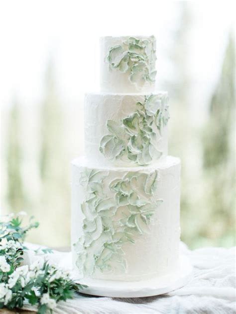 Torta nuziale bianca con fiori e foglie verdi