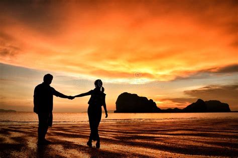 Coppia che celebra il matrimonio in spiaggia al tramonto