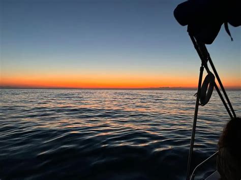 Imbarcazione che naviga al tramonto lungo la costa del Conero