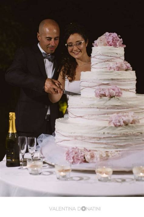 Coppia di sposi che taglia la torta nuziale in montagna