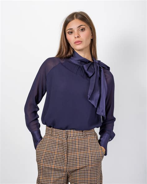 Dettagli di una blusa elegante: fiocco e maniche a sbuffo