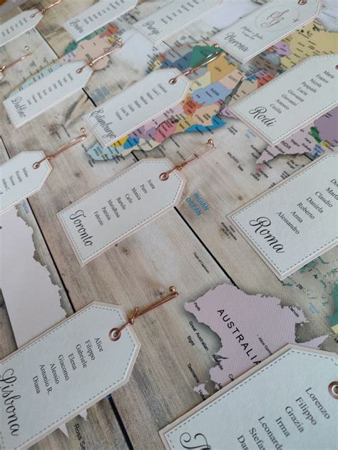 Esempi di coordinati grafici per matrimonio a tema viaggio: tableau, segnaposto, menu.