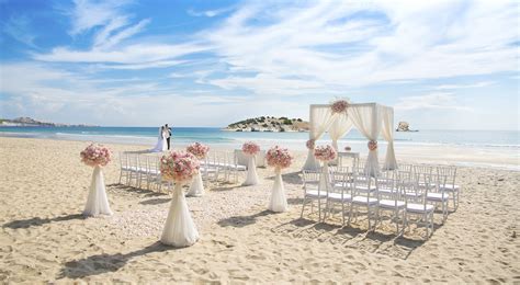 Coppia che celebra un matrimonio su una spiaggia greca al tramonto