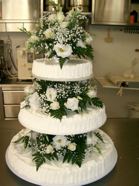 Torta nuziale minimalista a un piano con decorazioni floreali discrete