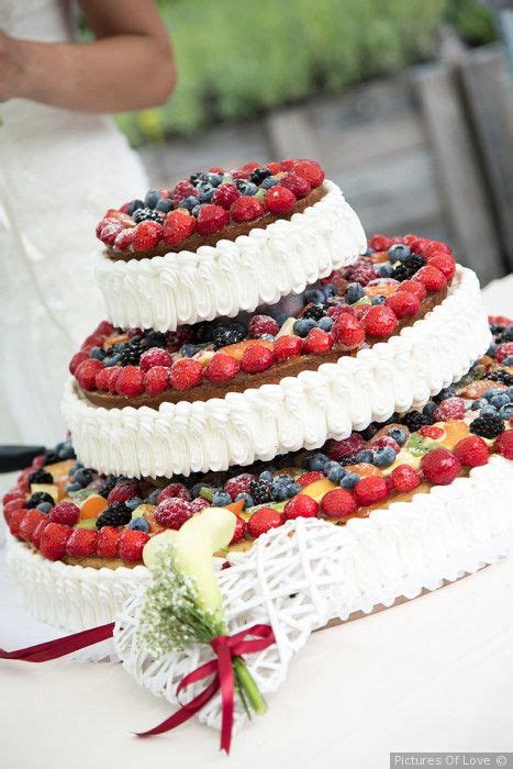 Composizione di torte nuziali a un piano con diverse decorazioni: frutta, fiori, glassa