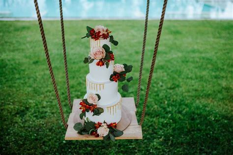 Struttura altalena per torta nuziale decorata con fiori