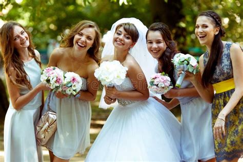 Gruppo di damigelle felici che aiutano la sposa